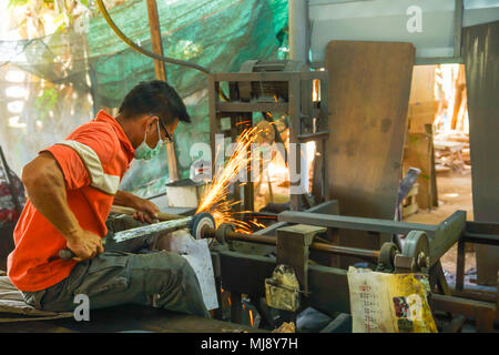 Lampang, Thailand - November 2, 2012: Schwert Teekocher schleifen Schwert mit Schleifen elektrische Maschine in der Werkstatt in Lampang, Thailand Stockfoto