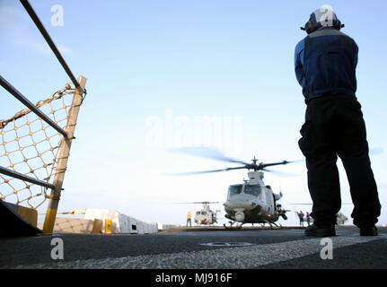 180419-N-GR 168-0136 MITTELMEER (19. April 2018) der Luftfahrt Bootsmann Mate (Handling) Airman Adrian Lopez aus Fontana, Kalifornien, steht der Landung einweisende Watch auf dem Flugdeck der San Antonio eingetragen - Klasse amphibious Transport dock Schiff USS New York (LPD 21) April 19, 2018. New York, homeported in Mayport, Florida, ist die Durchführung von naval Operations in den USA 6 Flotte Bereich der Operationen. (U.S. Marine Foto von Mass Communication Specialist 2. Klasse Lyle Wilkie/Freigegeben) Stockfoto