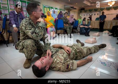 180424-N-MW 694-0153 Tawau, Malaysia (24. April 2018) Cmdr. Christopher Jack und Royal Army Medical Corps Cpl. Darren Phillips, zugeordnet zu den pazifischen Partnerschaft 2018 (PP18), zeigen die Reaktion auf einen Unfall während einer Erste Hilfe Ausbildung bei der SMK Balung Secondary School statt, am 24. April. PP18's Mission ist es, gemeinsam mit Gastgeber und Partner Nationen zu arbeiten regionaler Interoperabilität und Disaster Response Funktionen, erhöhen die Stabilität und Sicherheit in der Region zu stärken, und neue und dauerhafte Freundschaften in der gesamten indopazifischen Region fördern. Pazifische Partnerschaft, der nun in seinem 13. Iteration ist "i" Stockfoto