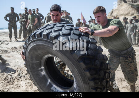 Us Marine Corps Sgt. Benjamin Rodriguez, ein Abschnitt Führer, und Lance Cpl. Mason Clark, ein Feuerwehrmann Techniker mit Sitz und Hauptverwaltung Squadron, Marine Corps Air Station Camp Pendleton, wirf eine große Reifen bei einem Krieger Nacht in Camp Pendleton, Kalifornien, 20. April 2018. Der Krieger der Nacht enthalten eine Reihe von physikalischen Ereignissen einschließlich Reifen Flips, Tauziehen, Capture the Flag, und sich festhalten. "Sie eins werden und sie als Team arbeiten", sagte Rodriguez. "Es soll, um das beste von uns, und als Team, wir können das schaffen." (U.S. Marine Corps Foto von Lance Cpl. Dalton Swanbe Stockfoto