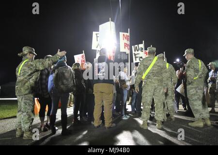 Vertriebene zivilen Akteuren inszeniert ein mock Protest, viele halten Schilder anspruchsvolle Nahrung, Wasser und Medizin. Kommandanten von der 864th Engineer Battalion (Herzschrittmacher), Joint Base Lewis-McChord, W. A., schnell versucht, die Kontrolle über die Situation an der Responder Support Camp Jennings, Ind, während Wächter Antwort 18. Am 24. April 2018. Mehr als 4.500 Soldaten aus dem ganzen Land beteiligen sich an Wächter Antwort 18, a multi-component Training übung die Fähigkeit der US-Armee Einheiten', die Unterstützung der zivilen Behörden (DSCA) im Falle einer Chem Unterstützung zu validieren Stockfoto