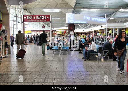 LONDON - 16. Mai: Reisende warten am Flughafen Stansted am 16. Mai 2012 in London. Es war der 4 verkehrsreichsten Flughafen in Großbritannien mit 17,4 Millionen Passagieren. Stockfoto