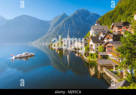 Klassische Postkarte Blick auf berühmte Hallstatt Stadt am See mit traditionellen Schiff im schönen Morgen bei Sonnenaufgang im Sommer, Salzkammergut, Österreich Stockfoto