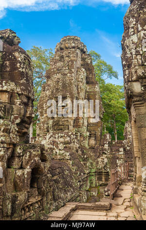 Turm mit alten Gesicht Skulpturen neben dem zentralen Heiligtum der Kambodschanischen Bayon Tempel in Angkor. Stockfoto