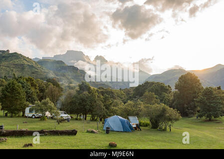 MONKS COWL, SÜDAFRIKA - 18. MÄRZ 2018: ein Zelt-, Caravan- und Fahrzeug auf dem Campingplatz bei Monks Cowl in den Drakensbergen. Cathedral Peak (links) und Stockfoto