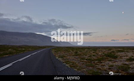 Island - blauen Himmel über der Straße zwischen Braun Wiese und vulkanischen Felsen Stockfoto