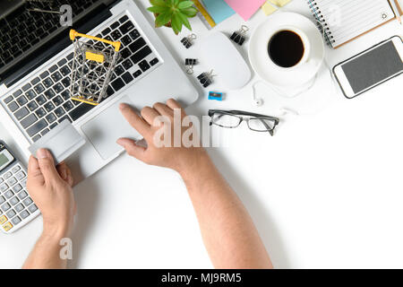 Ansicht von oben mit Kreditkarte für Online shoppen und andere Verbrauchsmaterialien mit Tasse Kaffee auf weißem Schreibtisch Mann. Online shopping Konzept. Stockfoto