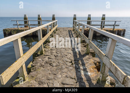 Pier mit Bootssteg am Abschlussdeich, Trennung Deich zwischen dem IJsselmeer und das Wattenmeer in den Niederlanden Stockfoto