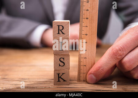 Der Unternehmer Hand Risikomessung Holzblöcke mit Lineal Stockfoto