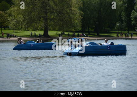 Menschen in Tretboote auf dem Serpentine im Hyde Park, London als Briten sehen Sie eine Feder Hitzewelle zu genießen, mit Feiertag Montag Prognose die heißesten überhaupt zu werden. Stockfoto