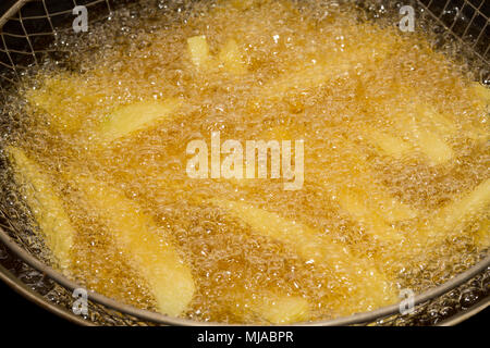 Frittieren Pommes frites in der Friteuse, Nahaufnahme Stockfoto