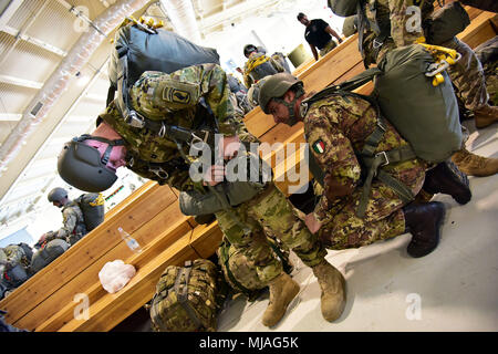 Italienische Heer Fallschirmjäger zu Folgore Brigade zugeordnet, kontrolliert die Fallschirm mit US-Armee Fallschirmjäger auf die 173Rd Airborne Brigade, während Jumpmaster Qualifikation, bei Aviano Air Base vor dem luftgestützten Hilfsaktionen auf Frida Drop Zone in Pordenone, Italien, 23. April 2018 führen. (U.S. Armee Foto von Paolo Bovo) Stockfoto