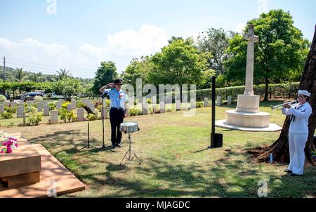 180425-N-RM 689-0066 TRINCOMALEE, Sri Lanka (25. April 2018) Royal Australian Air Force Gruppe Kapitän James Ross (links), begrüßt als Musiker Seaman Alyssa John (rechts), ein Mitglied der US-Pazifikflotte Band, spielt "Letzter Beitrag" auf der Trompete während der Australischen und Neuseeländischen Armee Korps (ANZAC) Tag der Erinnerung Festakt am Commonwealth Kriegsgräber Friedhof in Tincomalee. PP18's Mission ist es, gemeinsam mit Gastgeber und Partner Nationen zu arbeiten regionaler Interoperabilität und Disaster Response Funktionen, erhöhen die Stabilität und Sicherheit in der Region zu stärken, und neue und dauerhafte Frie fördern Stockfoto