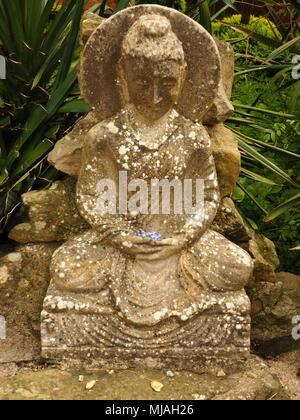 Statue des Bodhisattva, Hände legte mit blauen Blüten. Stockfoto