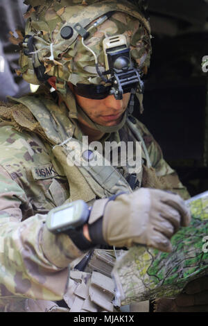 Us-Armee Sgt. Jesse Hunsaker, Amboss Truppe, 1st Squadron (Airborne), 91st Cavalry Regiment, 173Rd Infantry Brigade Combat Team (Airborne), wirft einen Blick auf eine Karte während einer Übung, Hohenfels, Deutschland, April 25, 2018. Das Joint Warfighting Bewertung (JWA) hilft die Armee aufkommende Konzepte zu bewerten, neue Technologien zu integrieren und Interoperabilität innerhalb der Armee zu fördern, mit anderen Diensten, US-Verbündeten und Partnern. JWA ist die einzige Übung Ort der Beurteilung 27 Konzepte und Fähigkeiten beim Ausrichten mit US-Armee Europa Bereitschaft und andere Komponente Übungen wie kombinierte Lösung von X und Stockfoto