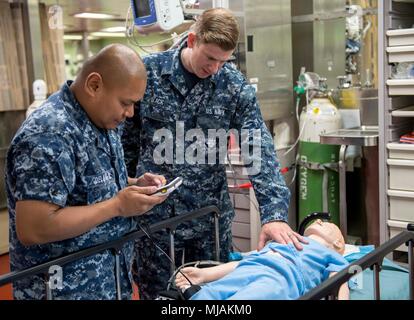180427-N-RM 689-0009 TRINCOMALEE, Sri Lanka (27. April 2018) Hospital Corpsman 2. Klasse Rudolf Delarea (links), ein Eingeborener von San Diego und Hospitalman Steven Black (rechts), ein Eingeborener von Prattville, Ala, richten Sie eine Simulation mannequin bei einer gemeinsamen chirurgische Simulation übung zwischen Military Sealift Command Hospital Ship USNS Mercy (T-AH 19) Service Mitglieder und lokale zivile medizinische Fachleute von Base Hospital Kantale zur Unterstützung der pazifischen Partnerschaft 2018 (PP18). PP18's Mission ist es, gemeinsam mit Gastgeber und Partner Nationen zu arbeiten regionaler Interoperabilität und Disaster speichereinbauort zu verbessern Stockfoto