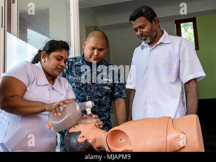 180428-N-RM 689-0145 TRINCOMALEE, Sri Lanka (28. April 2018) Hospital Corpsman 2. Klasse Rudolf Delarea (Mitte), ein Eingeborener von San Diego, die militärische Sealift Command Hospital Ship USNS Mercy (T-AH 19) zugeordnet ist für Pazifische Partnerschaft 2018 (PP18), lehrt, daß Sri Lankans, an der Basis Krankenhaus Mutur arbeiten wie CPR während einer medizinischen Ausbildung Symposium zu führen. PP18's Mission ist es, gemeinsam mit Gastgeber und Partner Nationen zu arbeiten regionaler Interoperabilität und Disaster Response Funktionen, erhöhen die Stabilität und Sicherheit in der Region zu stärken, und neue und dauerhafte Freundschaften, die über die Stockfoto