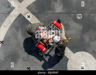 U.S. Navy Air Arewman (Hubschrauber) 2. Klasse Jay Wilson, Links, und Hospital Corpsman Patrick Langon, Rechts, an die Wildcards von Hubschrauber Meer Combat Squadron (HSC) 23, Laden einer trainingspuppe in eine Rettung Wurf von einem MH-60S Sea Hawk Hubschrauber während einer humanitären und Katastrophenhilfe Übung an Bord Military Sealift Command Hospital Ship USNS Mercy (T-AH 19) zur Unterstützung der pazifischen Partnerschaft 2018 (PP18) auf Trincomolee, Sri Lanka, 27. April 2018 zugewiesen. PP18's Mission ist es, gemeinsam mit Gastgeber und Partner Nationen zu arbeiten regionaler Interoperabilität und Disaster Response capabilit zu verbessern Stockfoto