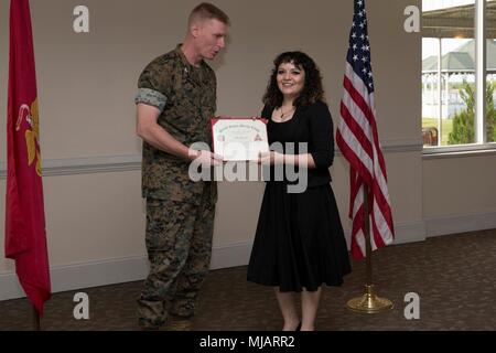 Colonel Russell Burton, Links, kommandierender Offizier, Marine Corps Air Station New River, stellt eine Auszeichnung zu Teresa Castaneda während der Präsidentschaftswahlen Auszeichnungen und freiwillige Anerkennung Zeremonie auf der Marine Corps Air Station New River, N.C., 26. April 2018. Der Zweck dieser Zeremonie wurde zu Ehren Marines und Familienangehörigen für Ihre umfangreiche Community Service von 100 Stunden oder mehr. (U.S. Marine Corps Foto von Lance Cpl. Ursula V. Smith) Stockfoto