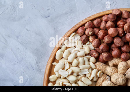 Gemischte Nüsse in braunen Schalen auf Holz- Fach auf weißem Hintergrund, - Nahaufnahme, Ansicht von oben, selektive konzentrieren. Köstliche, nahrhafte mischen. Bio Antioxidans. Ve Stockfoto