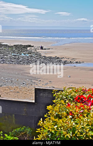 Eine junge Familie genießen den Strand bei Trecco Bay Porthcawl, S. Wales mit Blick über den Kanal von Bristol in Richtung North Devon Küste. Stockfoto