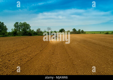 Luftaufnahme der Landwirt mit einem Traktor auf den landwirtschaftlichen Bereich Aussaat. Traktoren Arbeiten im landwirtschaftlichen Bereich im Frühjahr. Baumwollsamen Stockfoto