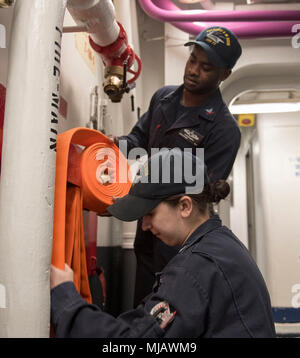 180430-N-FE 442-0028 Norfolk, VA (30. April 2018) der Maschinist Mate 2. Klasse Katlin Baumann aus Kakao, Florida, und der machinist Mate 2. Klasse Kurtis Smith, von Kingston, Jamaika, Stow einen Schlauch in einem Rack an Bord der Flugzeugträger USS George H.W. Bush (CVN 77). Das Schiff ist im Hafen in Norfolk, Virginia, die Durchführung von routinemäßigen Übungen Träger bereit zu halten. (U.S. Marine Foto von Mass Communication Specialist 3. Klasse Matt Matlage) Stockfoto