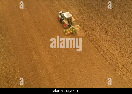 Luftaufnahme der Landwirt mit einem Traktor auf den landwirtschaftlichen Bereich Aussaat. Traktoren Arbeiten im landwirtschaftlichen Bereich im Frühjahr. Baumwollsamen Stockfoto