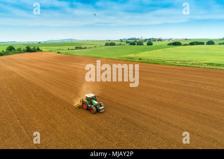 Luftaufnahme der Landwirt mit einem Traktor auf den landwirtschaftlichen Bereich Aussaat. Traktoren Arbeiten im landwirtschaftlichen Bereich im Frühjahr. Baumwollsamen Stockfoto