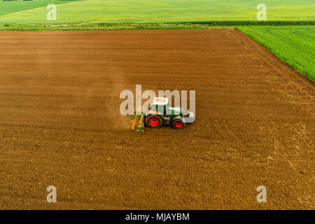 Luftaufnahme der Landwirt mit einem Traktor auf den landwirtschaftlichen Bereich Aussaat. Traktoren Arbeiten im landwirtschaftlichen Bereich im Frühjahr. Baumwollsamen Stockfoto