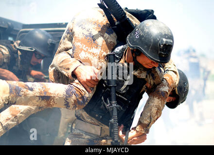 Südwesten Asien - Ein irakischer Terrorismusbekämpfung Student trägt seinen Kameraden während eines simulierten Improvised Explosive Device Angriff außerhalb der fiktiven Dorf Medina, Bagdad, 30. April 2018. Die Ausbildung in Medina Dorf wurde durch die Streitkräfte der Koalition zu helfen, CTS-Studenten ihre Kampftechniken wie Close Quarters Combat bauen, Ied identifizieren, die Einrichtung von Fahrzeug Checkpoints und Reagieren auf IED Angriffe. CTS ist die Grundlage für die Zukunft des Irak durch die Verbesserung ihrer Fähigkeiten, um ein sicheres und stabiles Umfeld für ihre Nation zu stellen. (U.S. Armee Foto von Sgt. William A. Stockfoto