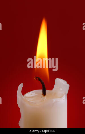 Nahaufnahme einer Kerze ligt auf rotem Hintergrund. Stockfoto