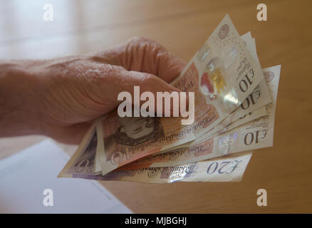 Nahaufnahme eines Rentner hand Übergabe etwas Bargeld Stockfoto