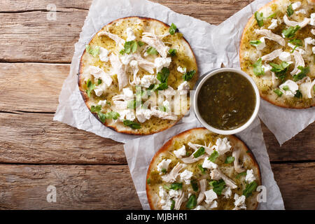 Mexikanische Chalupas mit Käse und Hähnchenfleisch und Sauce Salsa verde Closeup auf einem Tisch horizontal oben Ansicht von oben Stockfoto