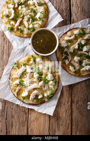 Mexikanische Chalupas mit Käse und Hähnchenfleisch und Sauce Salsa verde Closeup auf einem Tisch vertikal oben Ansicht von oben Stockfoto