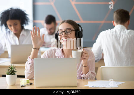 Entspannt Frau in Kopfhörer Musik auf dem Laptop in coworkin Stockfoto