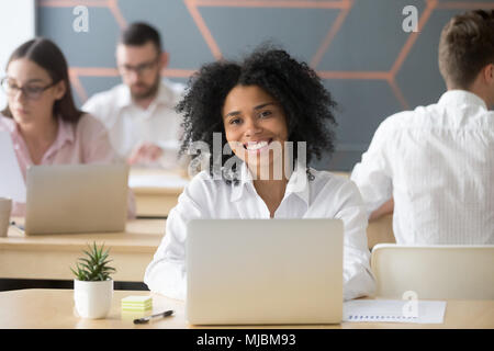 Lächelnd afrikanische Frau Mitarbeiter Student an der Kamera schaut in cowo Stockfoto