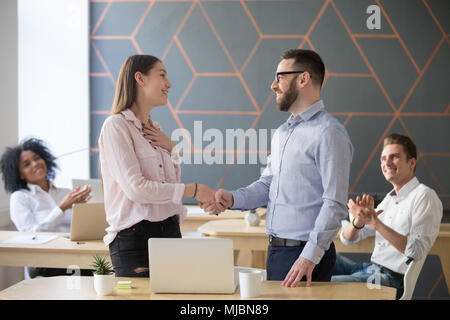 Boss handshaking erfolgreichen weiblichen Angestellten mit beglückwünschen. Stockfoto