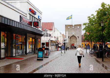 Visby, Schweden - 15. Mai 2016: Menschen in der Innenstadt von Visby in Ostercentrum mit dem Osterport Tor mit einer gehosteten schwedische Flagge auf der Stadtmauer Turm in der Stockfoto