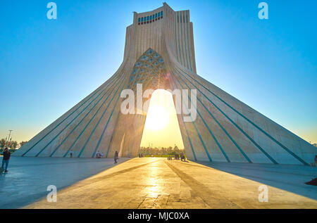 Teheran, Iran - Oktober 24, 2017: Romantischer Abend Blick auf Azadi Turm mit hellen Strahlen der untergehenden Sonne, am 24. Oktober in Teheran. Stockfoto