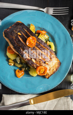 Gegrillter Lachs mit Gemüse serviert auf blauen Platte. Gesunde Mahlzeit. Stockfoto