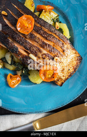 Gegrillter Lachs mit Gemüse serviert auf blauen Platte. Gesunde Mahlzeit. Stockfoto