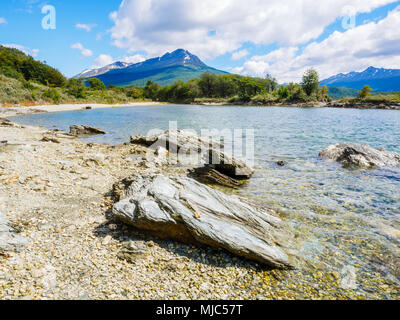 Steine am Strand von Bahía Lapataia Bucht mit Bergen im Hintergrund, Terra del Fuego National Park in der Nähe von Ushuaia, Patagonien, Argentinien Stockfoto