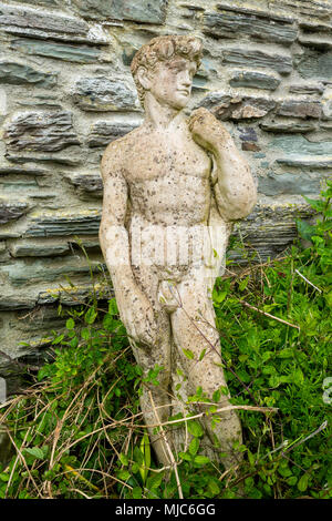 Garten Ornamente wie griechische Statuen langsam von Efeu und Clematis wächst in der Frühlingssonne überwuchert wird. Stockfoto