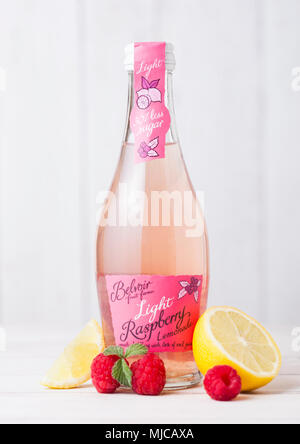 LONDON, Großbritannien - 27 April, 2018: Glas Flasche Belvoir Limonade trinken Limonade mit Himbeeren auf hölzernen Hintergrund mit rohen Früchten und Zitrone. Stockfoto