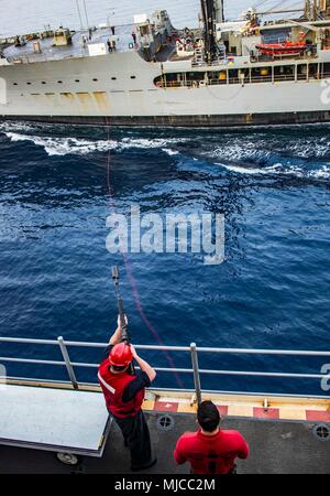 180501-N-NJ 910-0032 5. US-Flotte EINSATZGEBIET (1. Mai 2018) Aviation Ordnanceman 1. Klasse Shawn Wildenstein, von Yorba Linda, Calif., feuert einen Schuß aus dem Flight Deck der Wasp-Klasse amphibisches Schiff USS Iwo Jima (LHD7) zur Flotte Auffüllung öler USNS Big Horn (T-AO 198) während einer Auffüllung-auf-See, 1. Mai 2018. Iwo Jima in Mayport, Fla., ist homeported in die USA 5 Flotte Bereich für Maßnahmen zur Erhöhung der Sicherheit im Seeverkehr im Einsatz Verbündeten und Partnern zu beruhigen, und der Freiheit der Schiffahrt und des freien Handels in der Region erhalten. Stockfoto