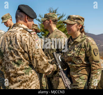 Us-Armee Sgt. Caitlin Johnson, ein Spezialist für die Hauptgeschäftsstelle Loslösung zugeordnet, 104 Militärpolizei Bataillon, New York Army National Guard (NYARNG), erhält die Bundeswehr Proficiency Abzeichen von Oberstleutnant Michael Breuer, der Deutschen Verbindungsoffizier von West Point, während die staatliche Ebene NYARNG besten Krieger Wettbewerb in West Point, New York, 21. April 2018. Die besten Krieger Wettbewerb statt, April 18-22, 2018, ist eine jährliche Veranstaltung, in der Junior Soldaten Soldaten und Unteroffiziere aus verschiedenen Einheiten konkurrieren in mehreren Veranstaltungen bestimmt sind ihre milita zu testen Stockfoto