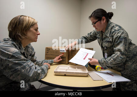 Kol. Jennifer Kurz, Links, 23d Wing Commander, und Senior Airman Evelyn Alvarado, 23 d Luft- und Raumfahrtmedizin Squadron öffentliche Gesundheit Techniker, eine Inspektion auf eine Mahlzeit, Ready-to-eat, 30. April 2018, bei Moody Air Force Base, Ga. Kurze Tourneen der 23d Medical Group (MDG) ein besseres Verständnis Ihrer gesamten Mission, Funktionen und umfassende Aufgaben zu gewinnen, und war in der Lage, den täglichen Betrieb zu Erleben der verschiedenen Einheiten innerhalb der 23d MDG, angefangen von bioenvironmental auf ambulante Pflege. (U.S. Air Force Foto von Airman 1st Class Eugene Oliver) Stockfoto