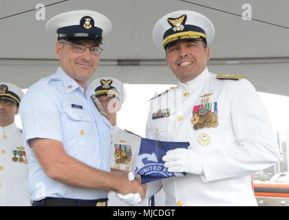 Master Chief Petty Officer Edward Lewis, command Master Chief für die Küstenwache 14. Bezirk präsentiert Hinten Adm. Vincent Atkins, Commander, Coast Guard 14. Bezirk eine persönliche Flagge bei einem Befehl und Ruhestand Zeremonie an der Coast Guard Base Honolulu, 2. Mai 2018. Die Änderung des Befehls Zeremonie ist eine altehrwürdige Tradition, die formell an die Offiziere bekräftigt, Soldaten, zivilen und Hilfskräfte der Einheit, die Kontinuität und die Autorität des Befehls. (U.S. Coast Guard Foto von Petty Officer 2. Klasse Tara Molle/Freigegeben) Stockfoto