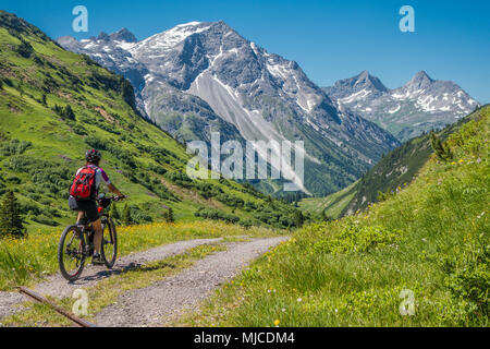 Ältere Frau Mountainbiking ine Berge in der Nähe von Lech am Arlberg, Tirol, Österreich Stockfoto